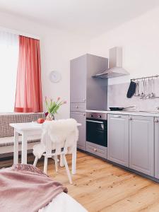 uma cozinha com uma mesa branca, uma mesa branca e um fogão em Villa Rosa em Bad Gastein
