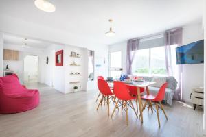 a living room with a dining room table and red chairs at Seaview 3 bedroom Kings Road Penthouse in Paphos