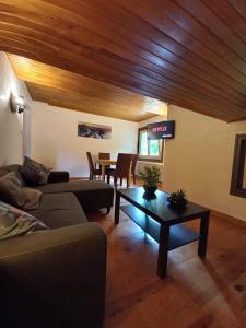 a living room with a couch and a table at Appartement mansardé dans maison avec jardin en bord de piste, vue montagne in Les Houches