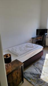 Cama en habitación con escritorio y cama sidx sidx sidx sidx en Hotel Kronprinz, en Emden