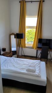 Hotel Kronprinz في إمدن: غرفة نوم بسرير ونافذة ذات ستائر صفراء