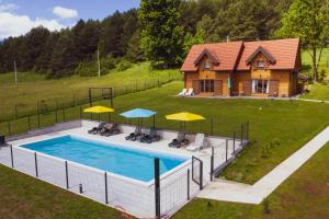 an overhead view of a pool with umbrellas and a house at Planinske kuce Good Night in Donji Babin Potok