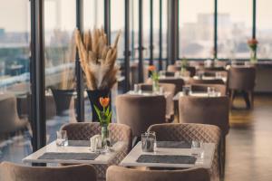 um restaurante com mesas e cadeiras com flores em Union Plaza Hotel em Bucareste