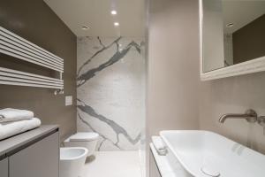 a bathroom with a sink and a tub and a toilet at Florence Luxury Apartment al Duomo by Mmega in Florence +21 photos