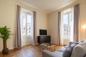 a living room with a couch and two large windows at Florence Luxury Apartment al Duomo by Mmega in Florence