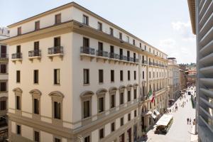 a large white building with people walking on a street at Florence Luxury Apartment al Duomo by Mmega in Florence