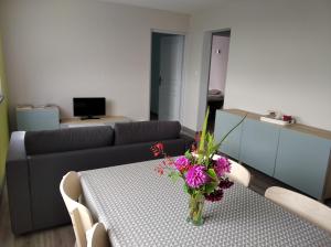 a living room with a couch and a table with flowers on it at Les figères - Les gites de Pierregras in Vals-les-Bains +13 photos