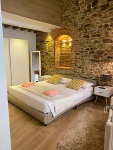 a bedroom with a large bed and a stone wall at La Torre di Borgunto - Piazza Grande in Arezzo