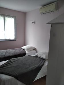 two beds in a room with a window at Les figères - Les gites de Pierregras in Vals-les-Bains