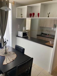 a kitchen with a black table and a counter top at Bonito y lindo departamento de vacaciones a metros de la Avenida del Mar in La Serena
