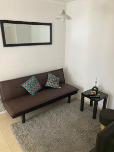 a living room with a brown couch and a table at Bonito y lindo departamento de vacaciones a metros de la Avenida del Mar in La Serena