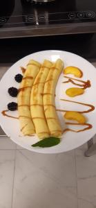 a white plate with sliced bananas and fruit on it at Red Cube Hotel in Kamianets-Podilskyi
