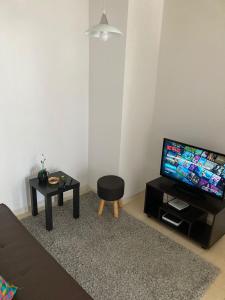 uma sala de estar com uma televisão de ecrã plano e um banco em Bonito y lindo departamento de vacaciones a metros de la Avenida del Mar em La Serena
