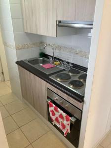 a kitchen with a stove and a sink at Bonito y lindo departamento de vacaciones a metros de la Avenida del Mar in La Serena