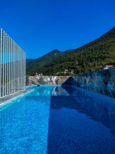 a large swimming pool with a mountain in the background at HOTEL CITRUS in Gagra