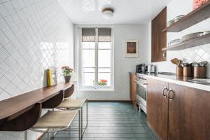 a kitchen with a counter and chairs in it at Pied A Terre - Saint Honoré in Paris