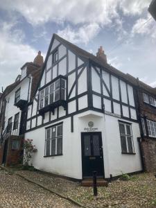 a white and black building with a black door at Oak Corner in Rye