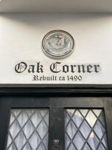 a sign above a door with a clock on it at Oak Corner in Rye