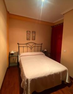 um quarto com uma grande cama branca num quarto em Albergue Buen Camino em Navarrete