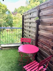 une table rose et deux chaises sur la terrasse dans l'établissement Appart proche gare + Parking , Impasse tranquille, à Montauban