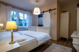 a bedroom with a bed with a lamp and a window at Penzion Enrico in Ždiar +49 photos