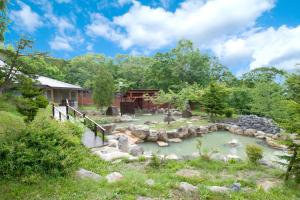 a garden with a pond and a house at Niseko Grand Hotel in Niseko