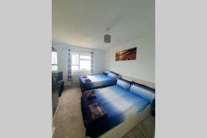a living room with a blue couch in a room at Chesil View in Castletown