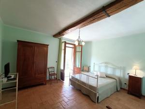 1 dormitorio con 1 cama y escritorio con TV en La Ca Veja, en Murisengo