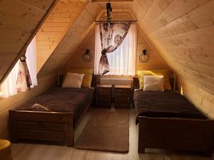 a bedroom with two beds in a attic at Chałupy Na Brzyzku in Poronin