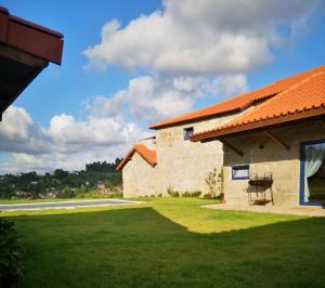 a house with a grass yard next to a building at Casa da Portela - Sem Igual in Meinedo