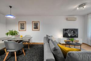 a living room with a couch and a table at Terra Magica Deluxe Apartment & Room with Private Parking, Terrace and Sea View in Rijeka