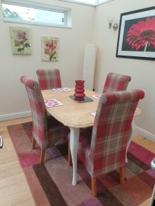 a dining room with a wooden table and chairs at Horseshoe Forge Plover Cottage Lindley in Huddersfield