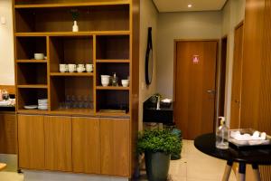 a kitchen with wooden cabinets and a table in a room at Água Branca Park Hotel in Araçatuba