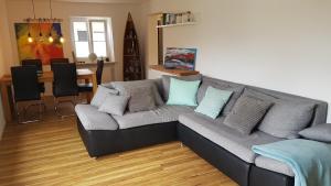 a living room with a gray couch with pillows at Apartment Weinbergglück in Ebringen