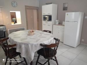 Appartement spacieux au coeur de la nature في Fougerolles: مطبخ مع طاولة مع كراسي وثلاجة