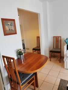 a dining room with a wooden table and two chairs at STUDIO 2 étoiles Rénové Proche des THERMES in Lamalou-les-Bains