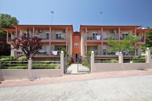 a building with a fence in front of it at Coralli Studios in Ormos Panagias