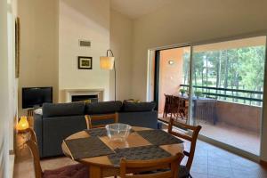 - un salon avec une table et un canapé dans l'établissement Aroeira - Sea & Golf Apartment, à Aroeira