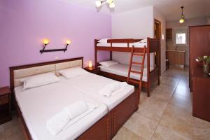 a bedroom with two bunk beds and a ladder at Coralli Studios in Ormos Panagias