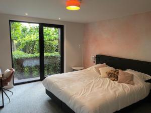 a bedroom with a large bed and a large window at Hotel - B&B Elementum in Kortrijk