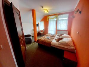 ein Schlafzimmer mit einem Bett in einem orangefarbenen Zimmer in der Unterkunft Willa Romantika in Kudowa-Zdrój
