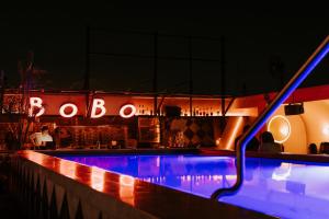 ein Pool in der Nacht mit einer Bar in der Unterkunft Brown BoBo, a member of Brown Hotels in Tel Aviv