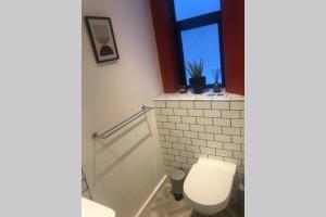 a bathroom with a white toilet and a window at Luxurious Studio in the heart of Cape Town CBD in Cape Town