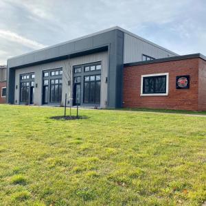 a building with a grass field in front of it at Station 1 by Terra Hospitality in Moncton