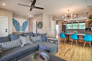 a living room with a blue couch and a kitchen at Bright Tybee Island Townhome - Walk to the Beach! in Tybee Island