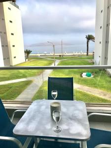 a table with two wine glasses on top of it at Paracas Paracas! 2do Piso Vista al Mar 133 Metros - Sotavento 201 T6 in Paracas