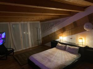 1 Schlafzimmer mit einem Bett mit 2 Lampen und einem TV in der Unterkunft White House in Aosta