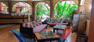 - un salon avec des canapés, des tables et des chaises dans l'établissement Cool Vibes Beach Hostel, à Dominical