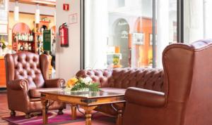 two leather chairs and a coffee table in a salon at Escuela-Hotel Convento Santo Domingo in Archidona