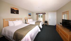 a hotel room with two beds and a flat screen tv at Fisherman's Landing Inn in Rocky Harbour